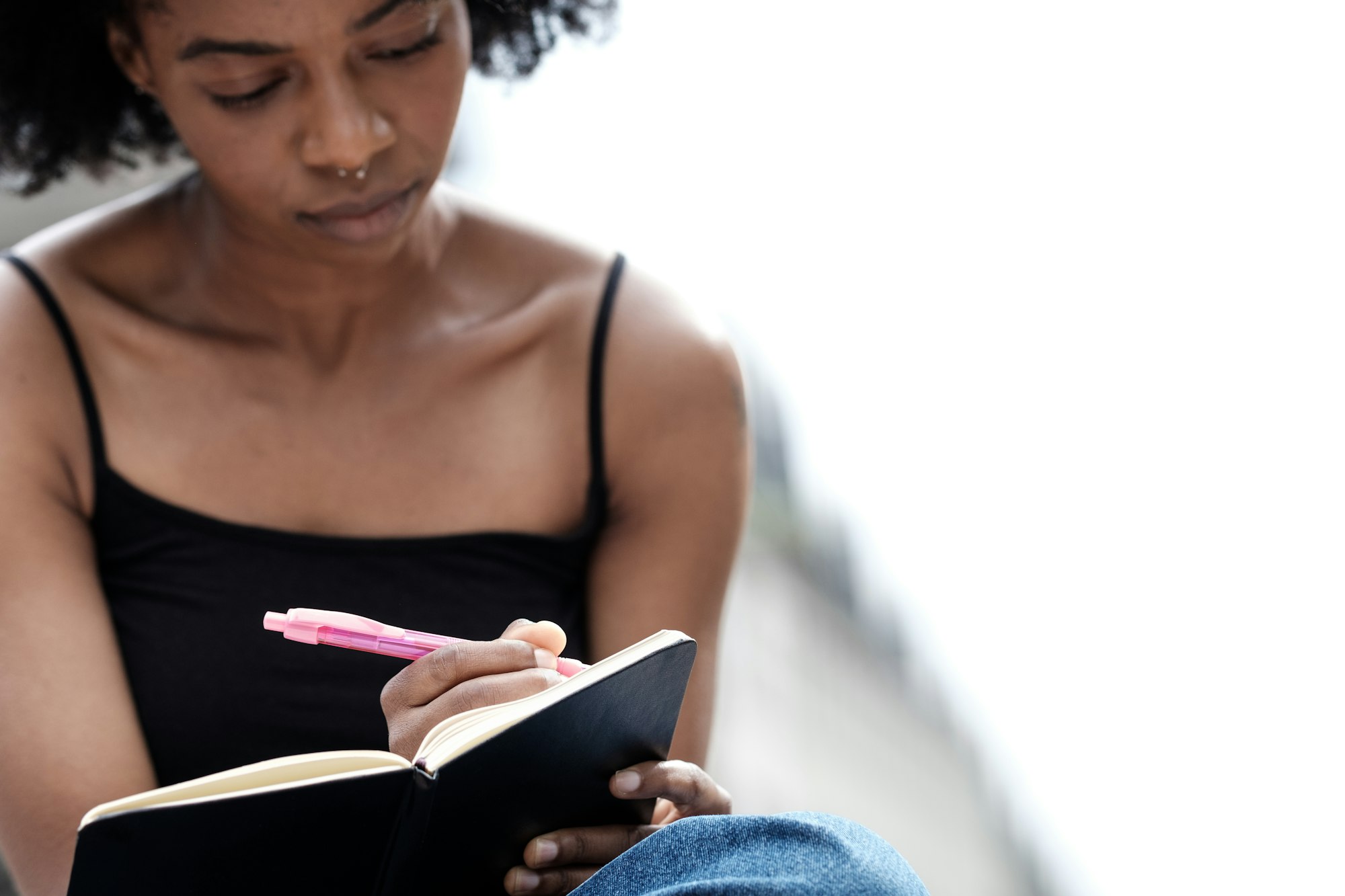 Blurry black woman handwriting on a journal.