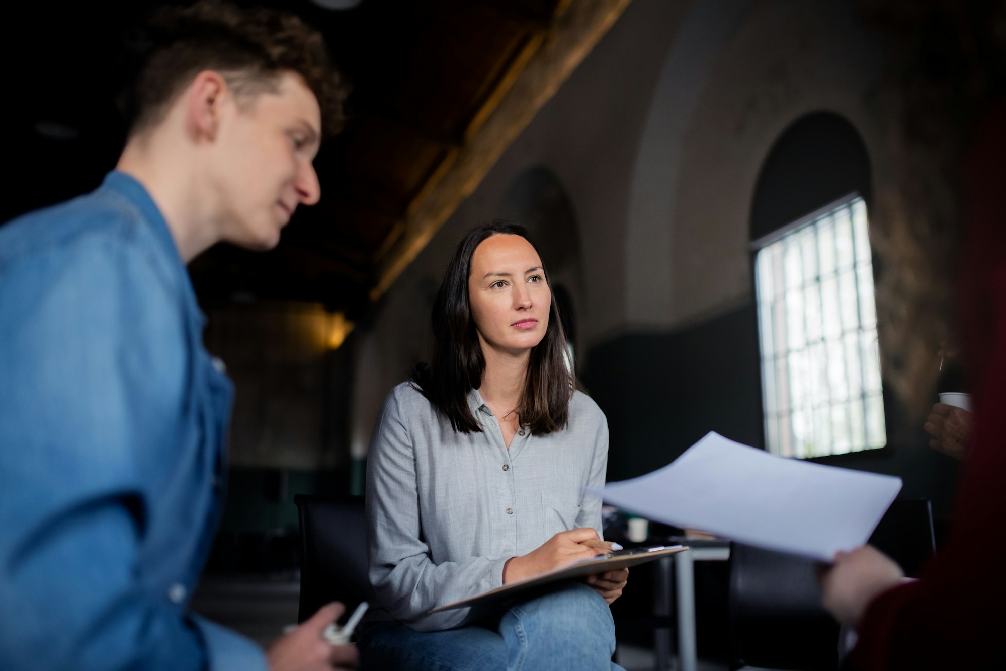 Counselor with people sitting in circle during group therapy, talking