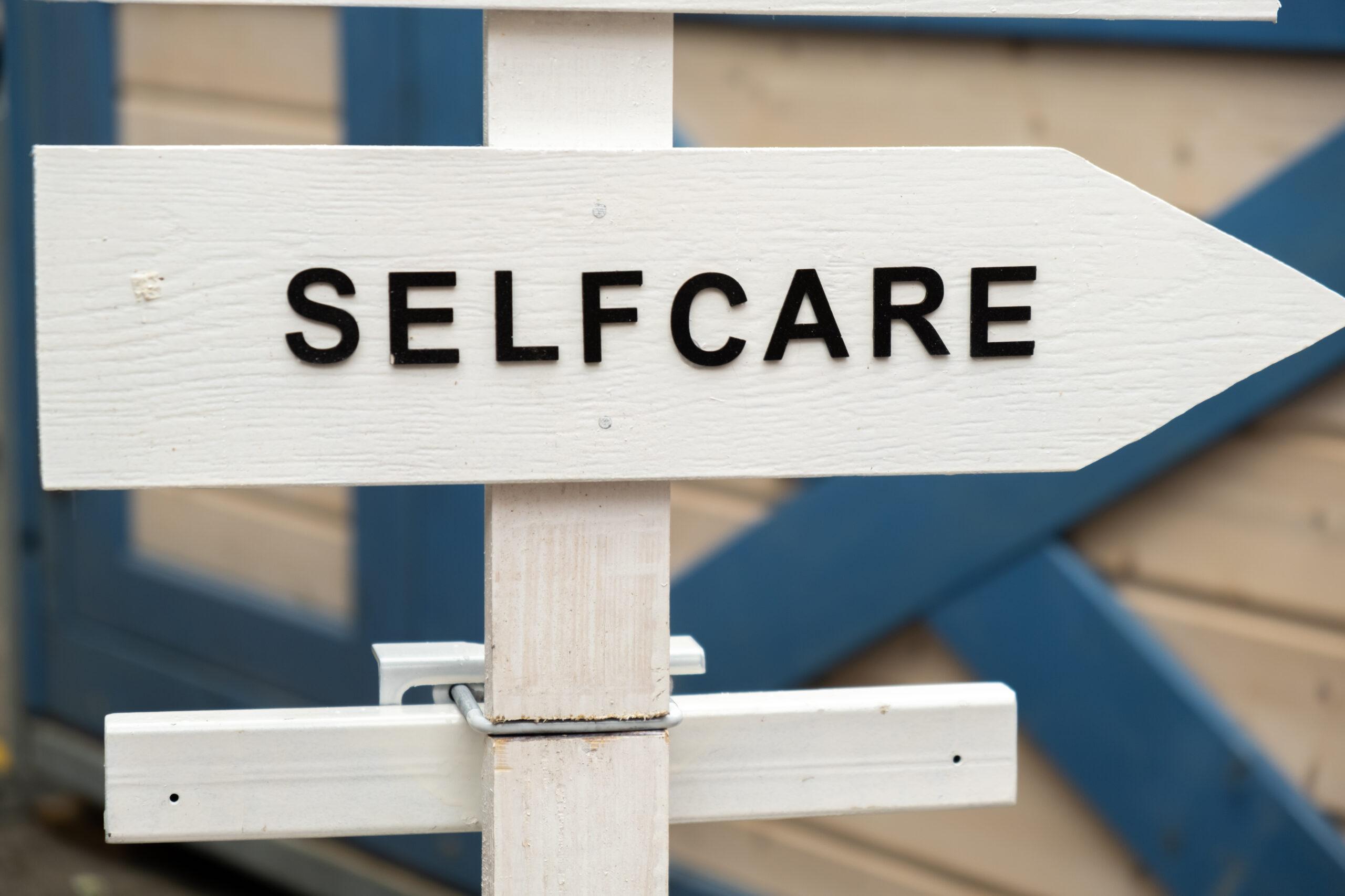 a street sign with the words "self care" pointing right, highlighting the importance of National Self Care Day