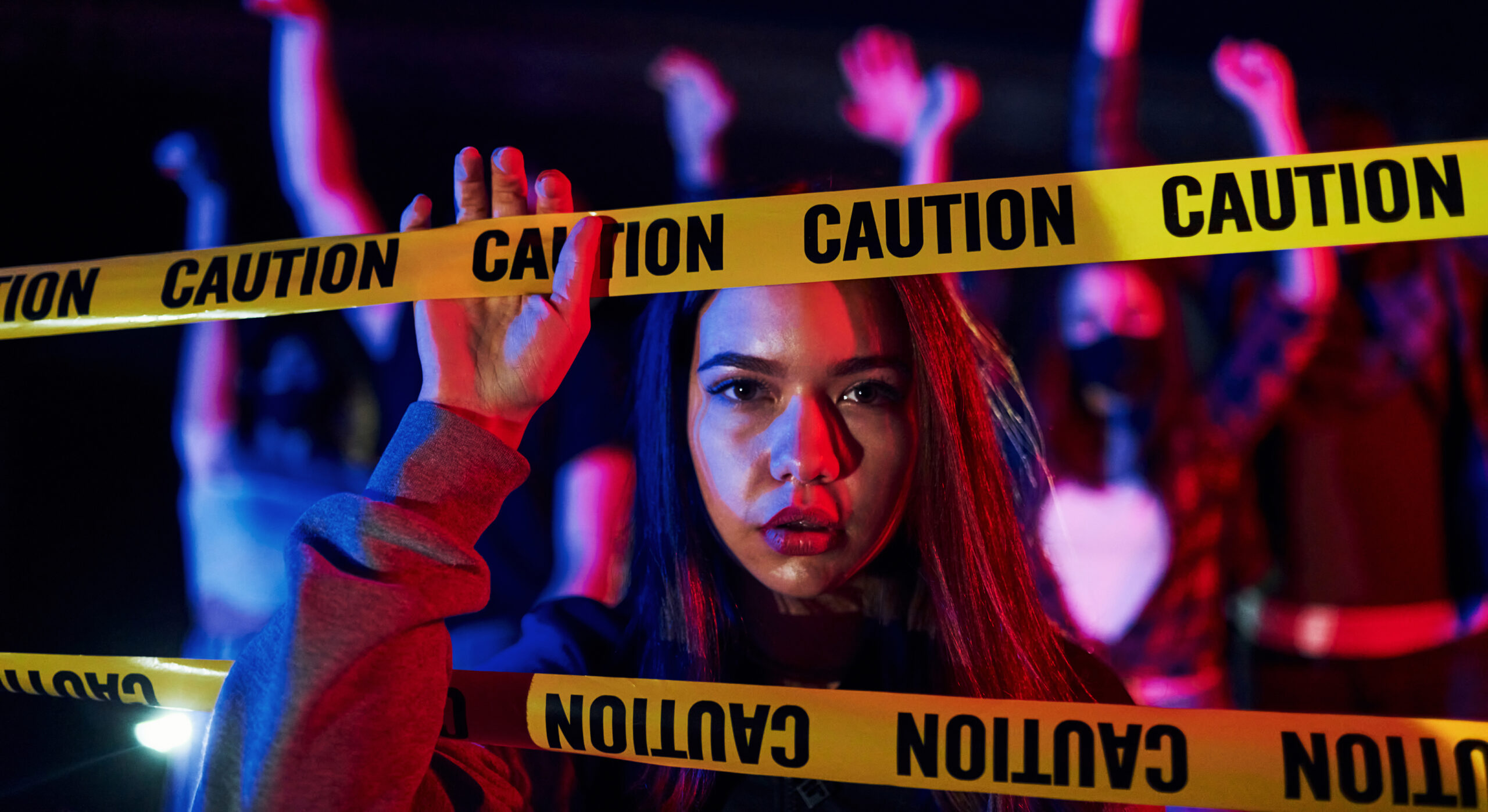 a girl caught in between caution tape, representing the need for awareness on rainbow fentanyl